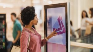 mulher interagindo com painel de mídia OOH